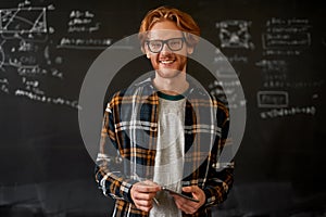 Male teacher near blackboard with programming code