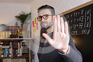 Male teacher showing stop sign with hand gesture