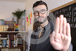 Male teacher showing stop sign with hand gesture