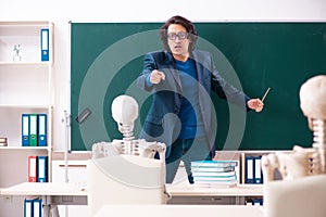 The male teacher and skeleton student in the classroom