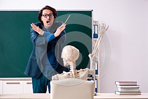 The male teacher and skeleton student in the classroom