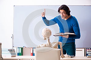 The male teacher and skeleton student in the classroom