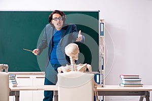 Male teacher and skeleton student in the classroom