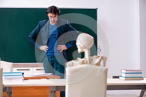 Male teacher and skeleton student in the classroom