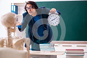 Male teacher and skeleton student in the classroom