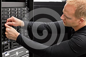 Male Technical Consultant Adjusting Hard Drives In SAN At Datace