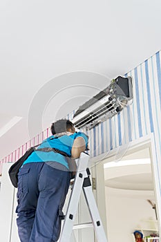 Male technician checking an air conditioner