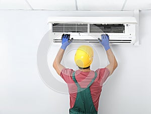 Male technician checking air conditioner