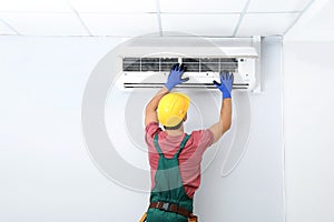 Male technician checking air conditioner