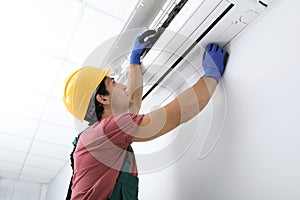 Male technician checking air conditioner