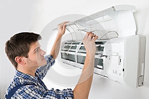 Male Technician Cleaning Air Conditioning System