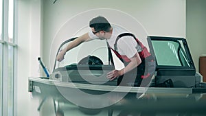 Male technician is cleaning windshield of a sailboat