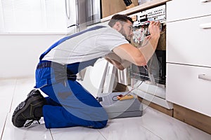 Male Technician Examining Dishwasher