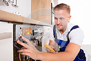 Male Technician Fixing Dishwasher