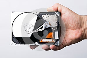 Male technician hand holding computer hard drive over white back