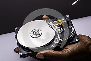 Male technician hand holding and working on  computer hard drive with scewdriver