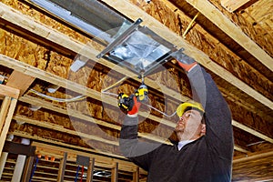 Male technician mounted air conditioner on ceiling ventilation system