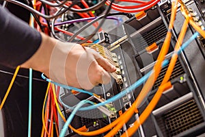 Male Technician Plugging Fiber Channel Network Cable In Blade Server Switch