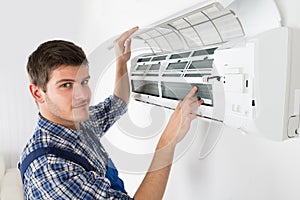 Male Technician Repairing Air Conditioner