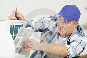 male technician repairing air conditioner