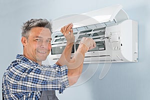 Male technician repairing air conditioner