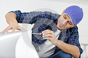 Male technician repairing air conditioner at home