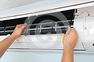 Male technician repairing air conditioner indoors, closeup