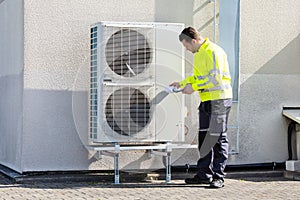 Male Technician Repairing Air Conditioner Outdoors