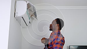 Male Technician Repairing Air Conditioner With Screwdriver In Home