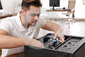 Male technician repairing computer at table