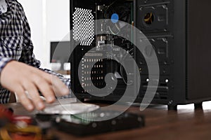 Male technician repairing computer at table
