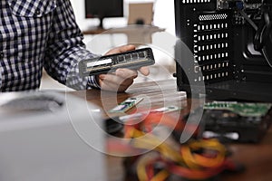 Male technician repairing computer at table