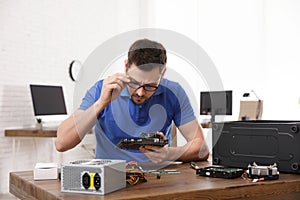 Male technician repairing computer at table