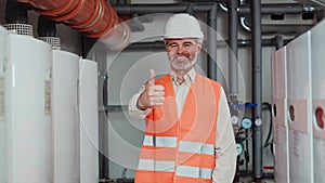 Male technician standing at workplace smiling at camera and showing thumb up