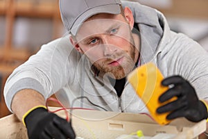 male technician tests appliance with multimeter