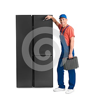 Male technician with tool box near refrigerator on background