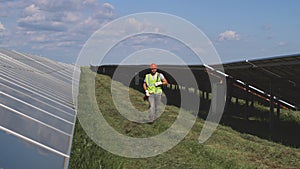 Male technician walking near solar panels