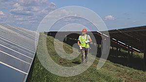 Male technician walking near solar panels