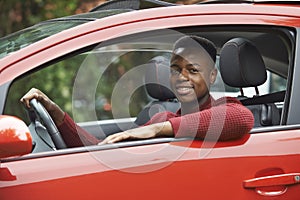 Male Teenage Driver Looking Out Of Car Window