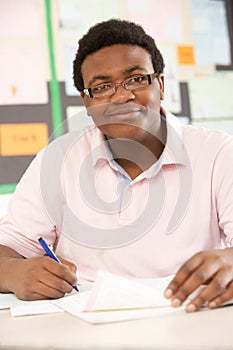 Male Teenage Student Studying In Classroom