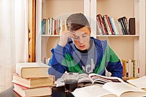 Male teenager drinking coke while studying