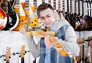 Male teenager examining electric guitars