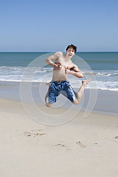 Male Teenager Jumping On Beach