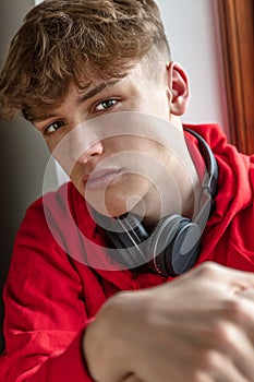 Male Teenager Young Adult Wearing Red Hoodie and Wireless Headphones