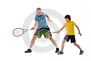 Male tennis player, coach training with teen to play tennis isolated over white studio background. Concept of sport