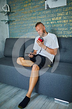 Male testing talking smart wireless speaker, man controlling home devices with a voice commands