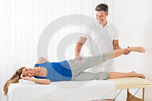 Male Therapist Giving Leg Massage To Woman