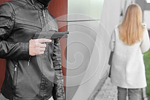 Male thief with gun is going to steal from woman outdoors