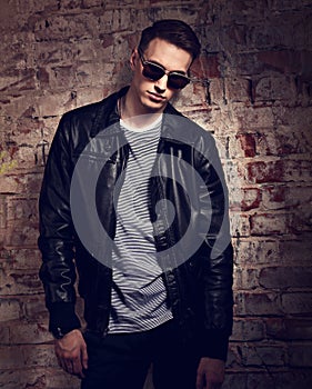 Male thinking model posing in leather jacket and trendy eyeglass