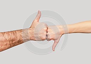 Male thumb up sign, female thumb down sign. Concept of good and bad, agreement and disagreement